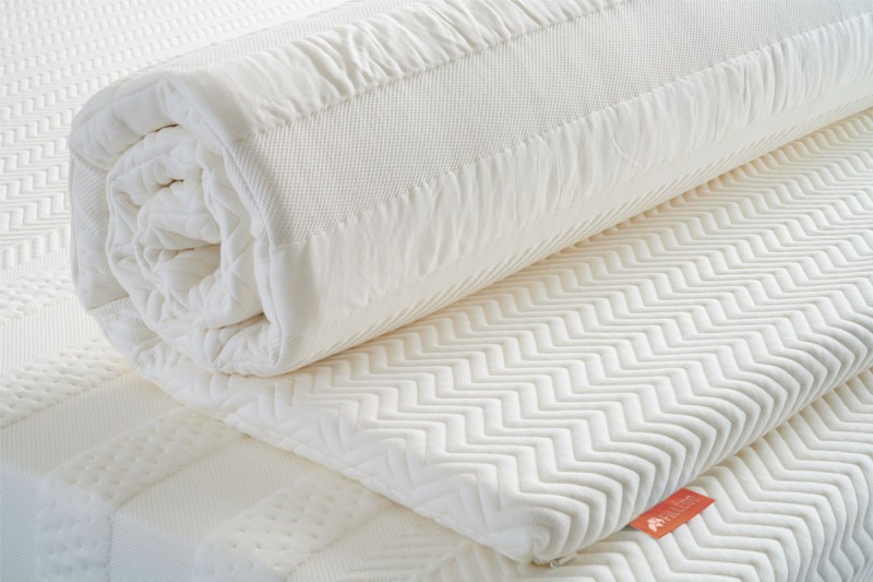 opgerolde witte latex topmatras op witte matras
