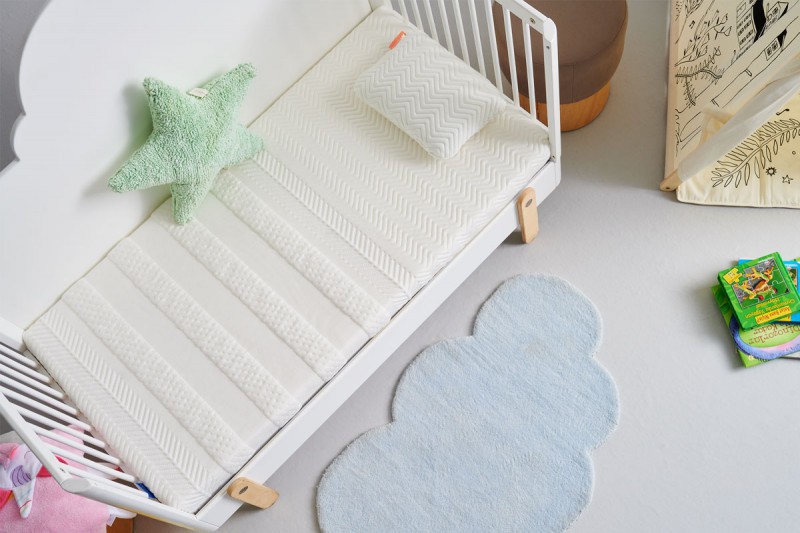 witte babymatras op wit babybed met wit kussen in een baby kamer
